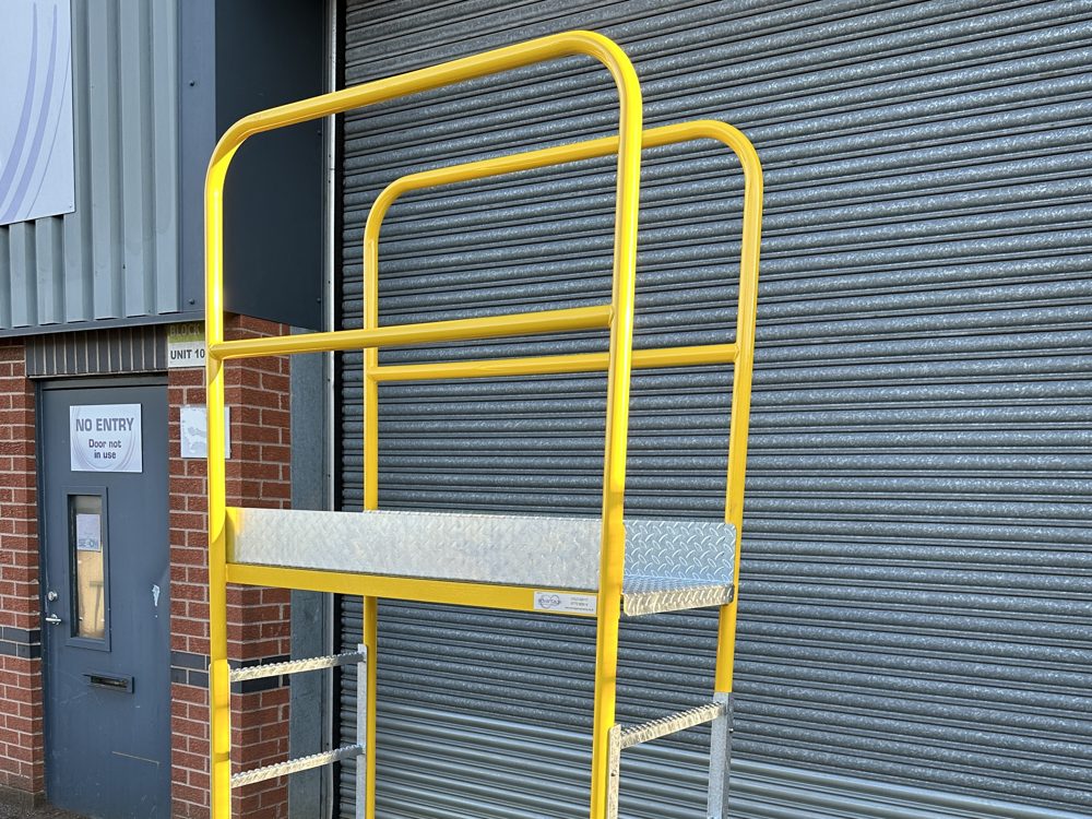 Yellow powder coated handrails with top and mid rails above a chequer plate platform deck